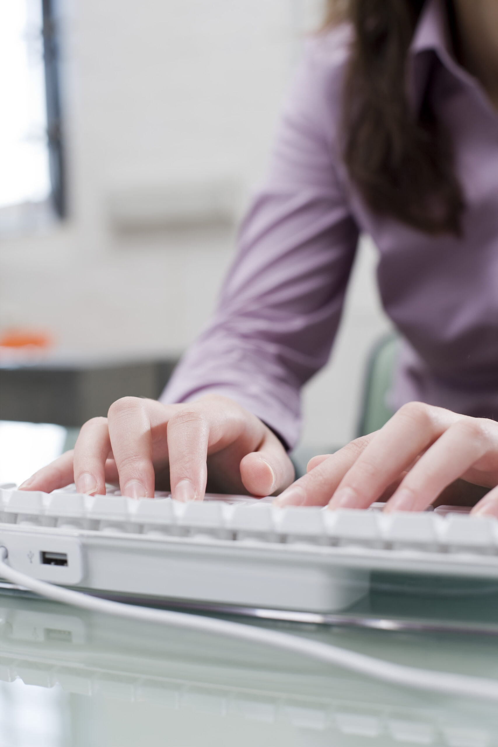 Woman typing on computer, close-up